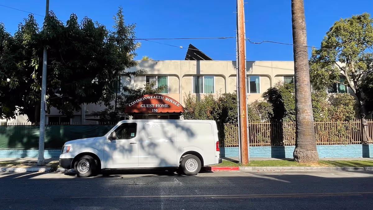 Front exterior of the Commonwealth Royale guest home with a white van parked on the street.