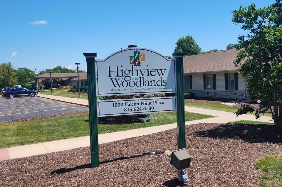 Freestanding sign reading "Highview in the Woodlands" on a landscaped lawn with the facility building and parking lot behind it.