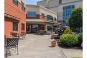 Outdoor courtyard at Spring Creek facility with seating, planters, and brick and beige building.