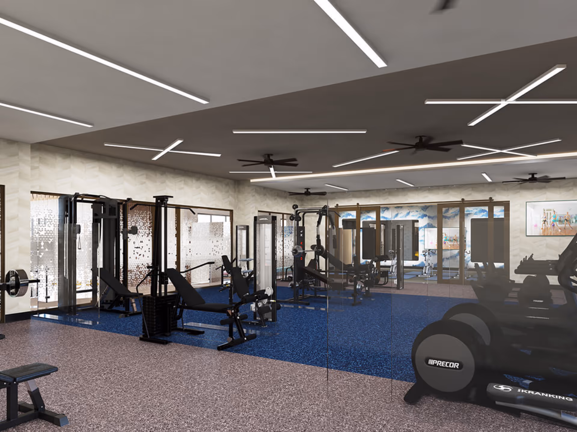 Modern indoor fitness center with weight machines, benches, treadmills and a mirrored wall.