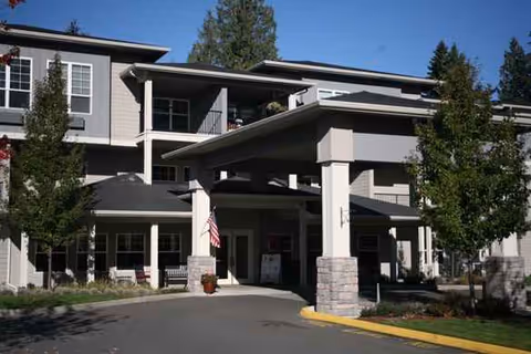 Exterior view of Cedar Ridge by Bonaventure, a multi-story senior living building with a covered entrance.