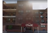 Front exterior of a multi-story brick nursing facility with a maroon entrance canopy reading "CN & RC" and the number "300" above the doorway.