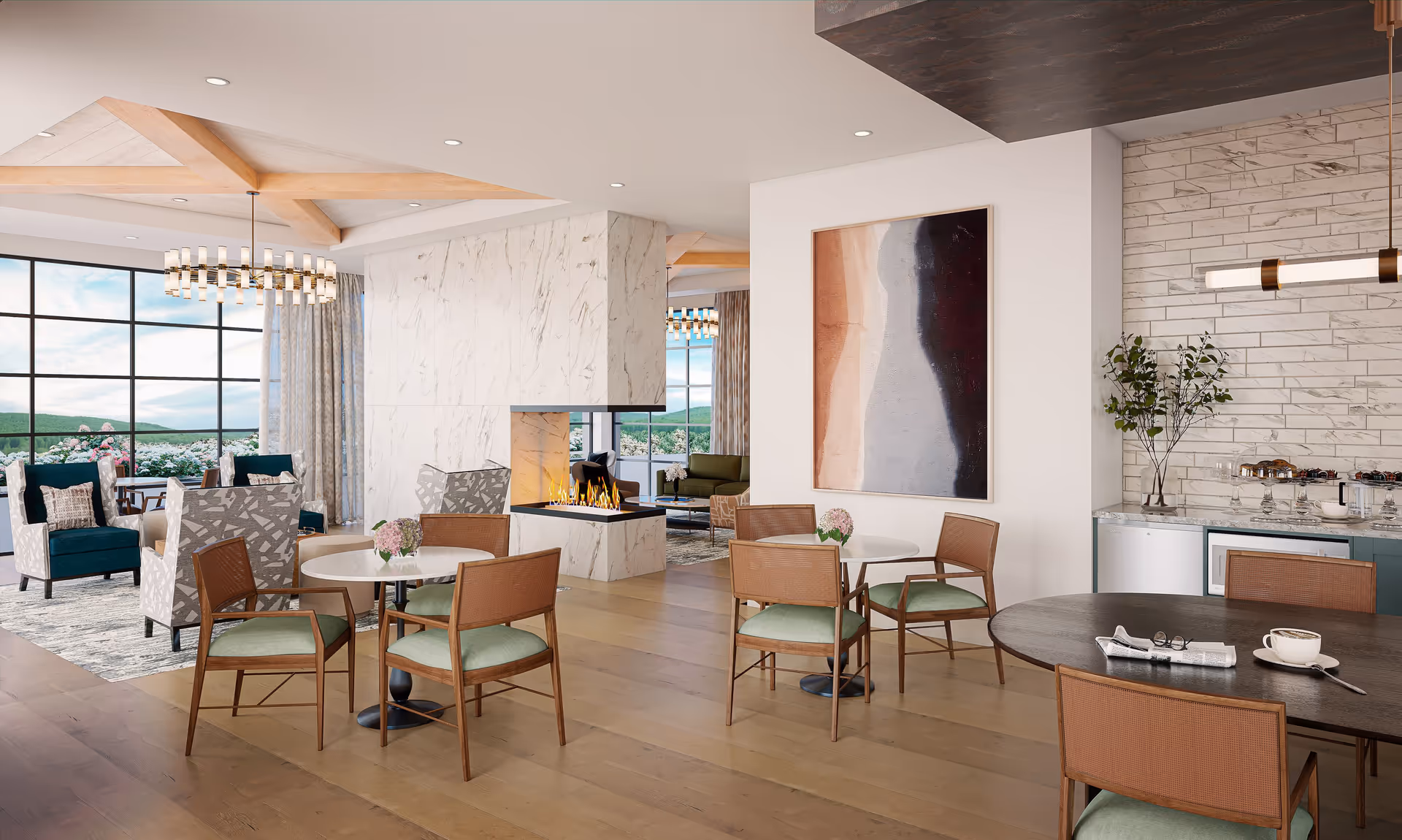 A modern and elegant common area in a senior living facility featuring multiple seating arrangements with wooden chairs and tables, a central marble fireplace, large windows with scenic outdoor views, contemporary chandeliers, and decorative artwork on the walls.