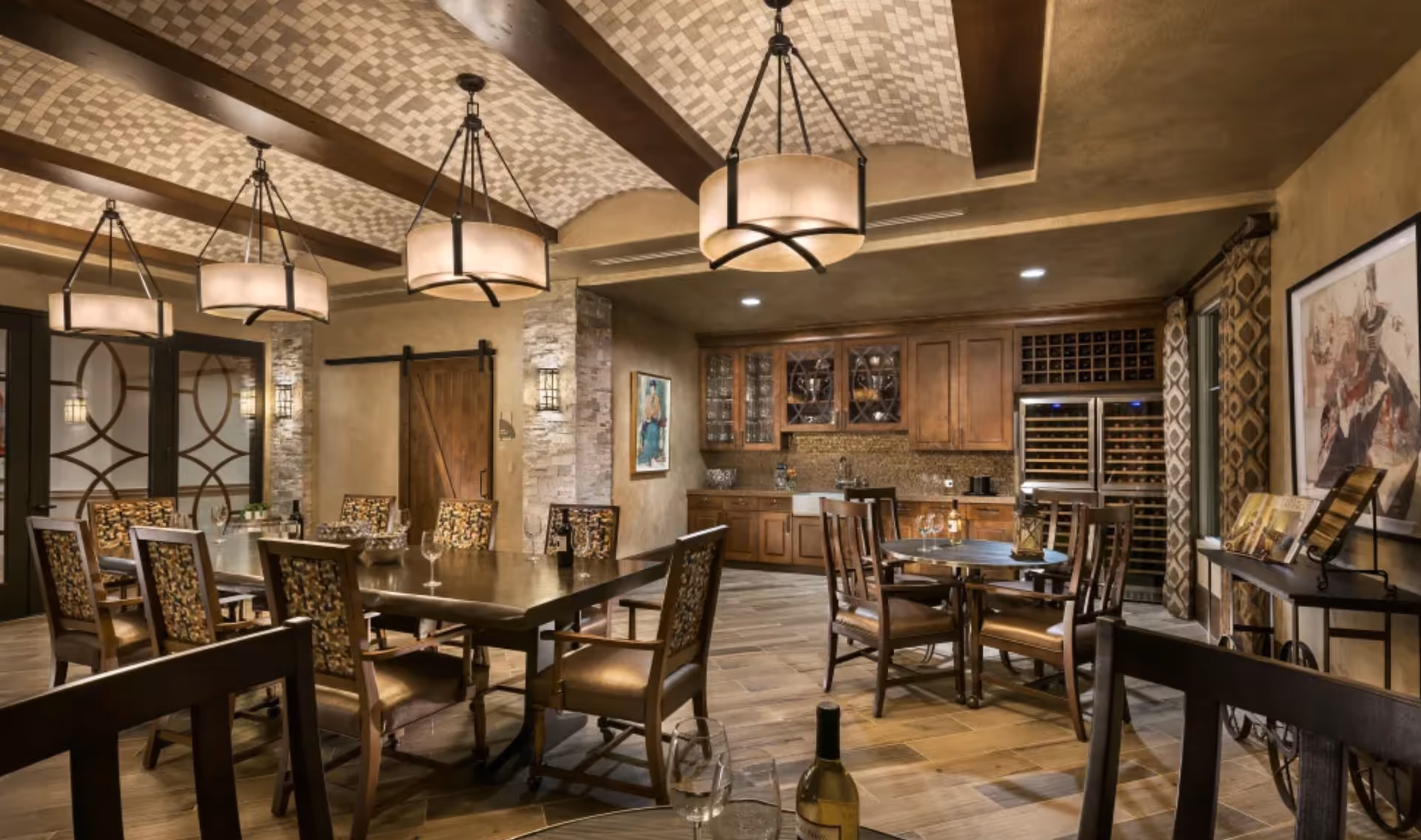 Spacious, elegant dining area with multiple tables and chairs, pendant lights, and a built-in wooden wet bar and wine storage.