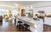 Bright open-concept kitchen at Willamette View Terrace with island, stools, and adjacent dining area.