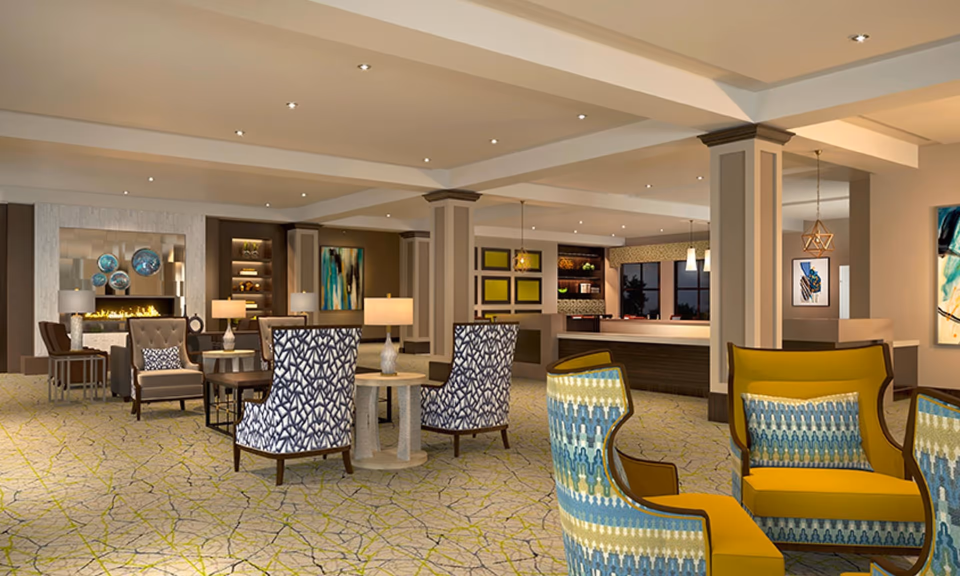 A spacious and well-lit senior living facility common area with modern furniture including patterned armchairs, side tables with lamps, and a fireplace in the background. The room features neutral walls, decorative artwork, and recessed ceiling lights.