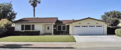 Front view of Golden Shore Care Home, a single-story house with a two-car garage and lawn.