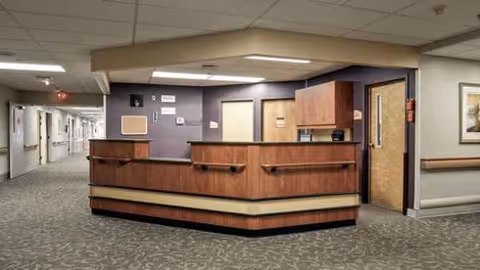 Reception desk in a hospital lobby with a long hallway and doors