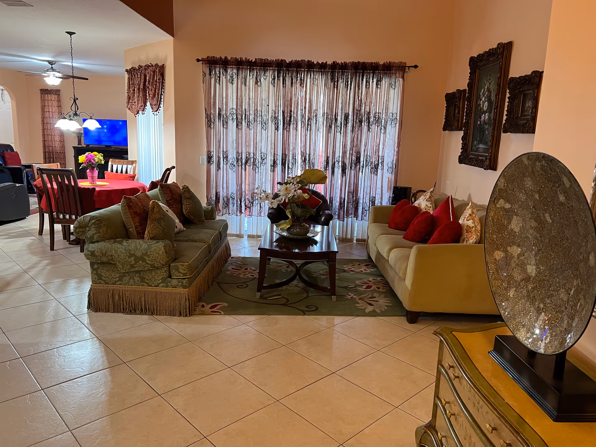 Open living room with two sofas, a coffee table and decorative pillows, with a dining table visible in the background.