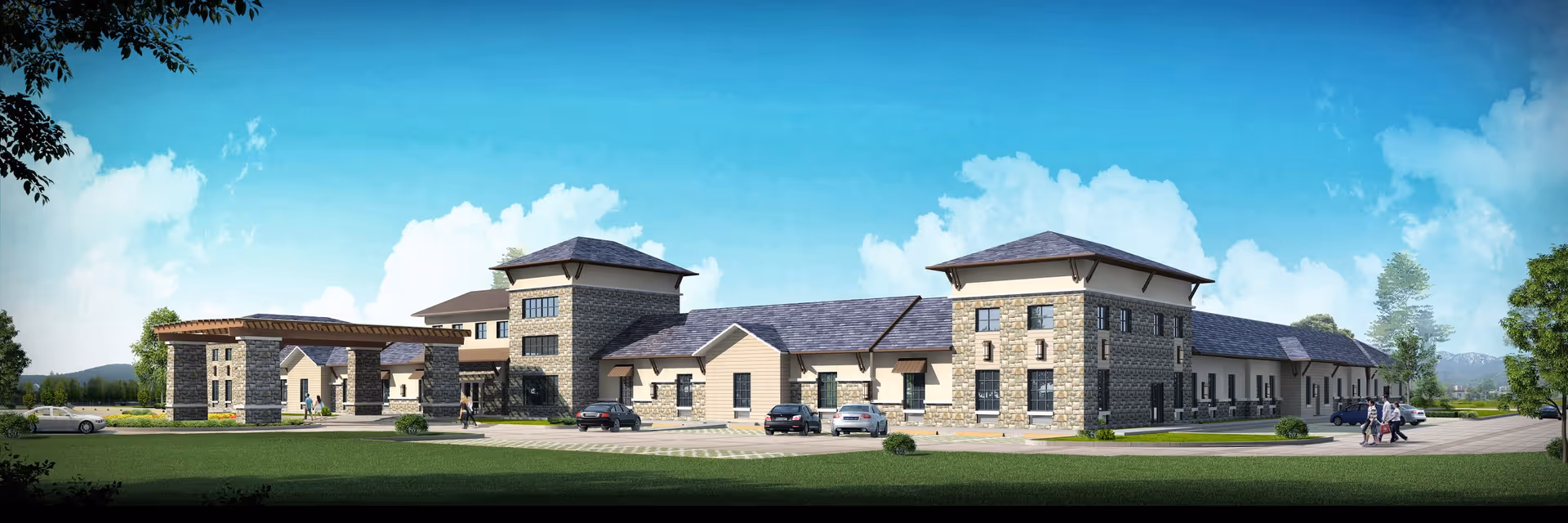 Exterior view of a large, modern senior living facility building with stone and beige siding, multiple peaked roofs, and a covered entrance. Several cars are parked in front, and a few people are walking near the entrance. The building is surrounded by green grass and trees under a bright blue sky with some clouds.