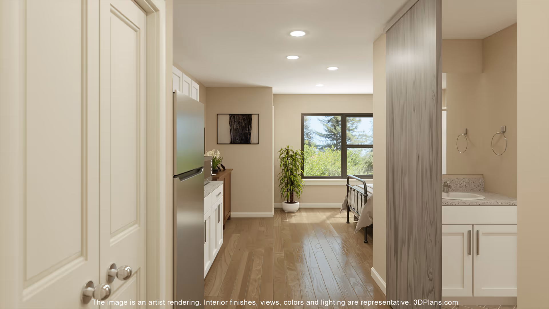 View of a senior living facility interior showing a hallway with a kitchen area on the left, a bedroom with a bed and a large window with greenery outside in the center, and a bathroom sink area on the right. The space features wood flooring, recessed ceiling lights, and neutral-colored walls.