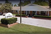Single-story brick senior living facility exterior with a manicured lawn and Amara sign.