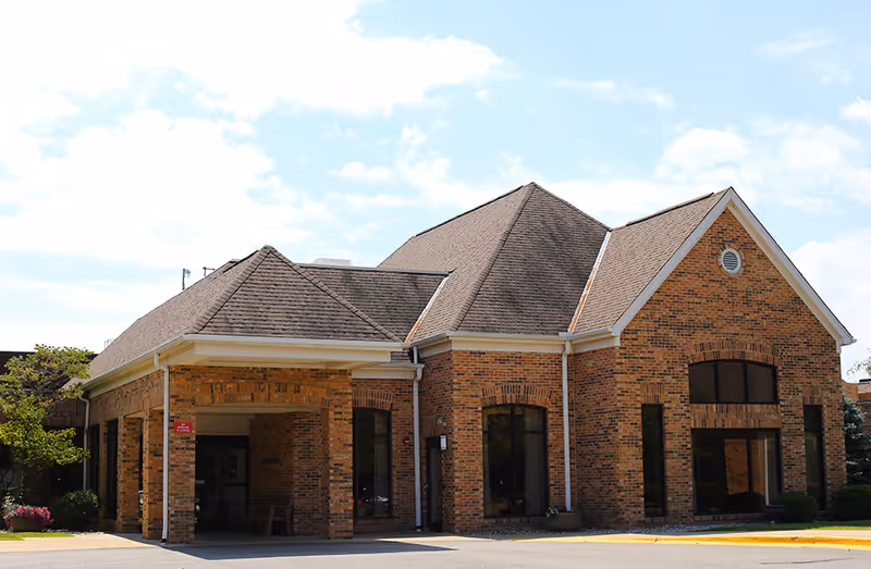 Vista Grande Villa exterior: brick building, gabled roof, and prominent front entrance.