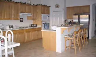Grace Manor Tracy kitchen with wooden cabinets, island counter, and stainless steel appliances.
