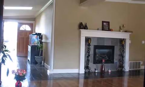 Spacious living room with fireplace, mantel decor, and an entry doorway visible to the left.