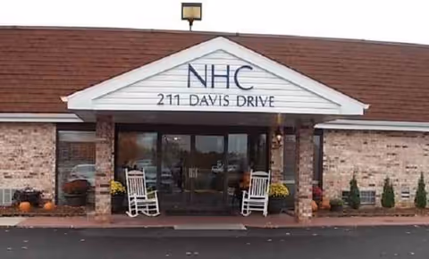 Front entrance of NHC Healthcare - West Plains at 211 Davis Drive with rocking chairs.