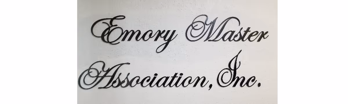 Decorative cursive wall sign reading "Emory Master Association, Inc." mounted on a light-colored wall.