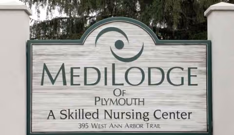 Medilodge of Plymouth sign with logo between two white pillars.