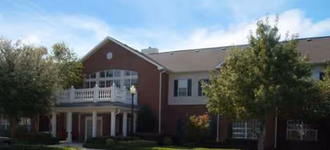 Brookdale Pecan Park building with brick exterior, balcony, and surrounding trees.
