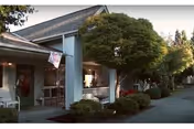 Exterior view of The Broadview Center entrance with a porch, trees, and walkway.