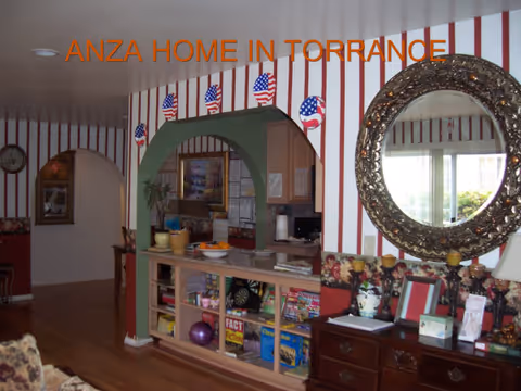 Interior common area with striped walls, archway, shelves, and round mirror.