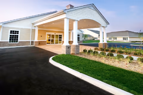 Front entrance of Ashton Creek Health and Rehabilitation Center with a covered driveway and landscaping