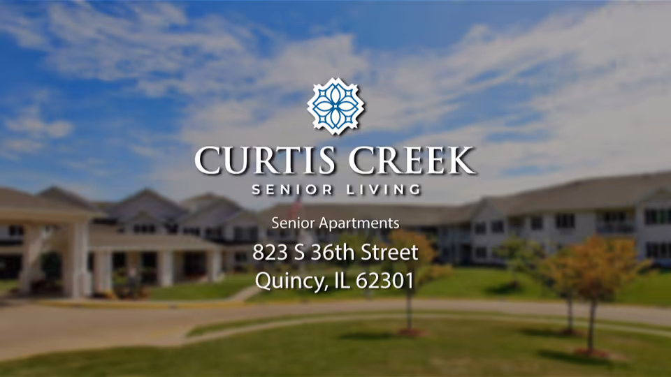 Exterior view of Curtis Creek Senior Living with logo and address overlaid on a blurred photo of the building.