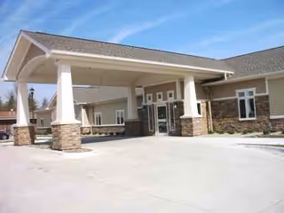 Front entrance of Spurgeon Manor with a wide covered drive and stone columns.