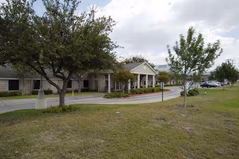 Exterior view of Regent Care Center of Laredo from the front with trees.