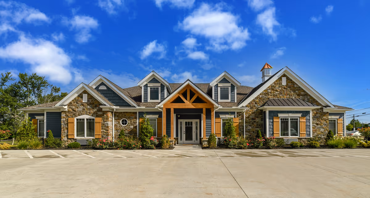 Front view of Cedar Living facility featuring stone exterior and neat landscaping.
