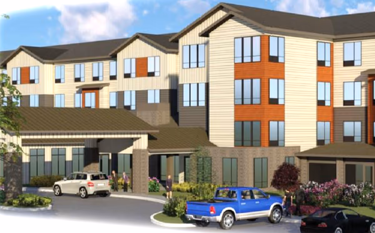 Front view of Riverwalk Estates Gracious Retirement Living building with driveway and parked cars.