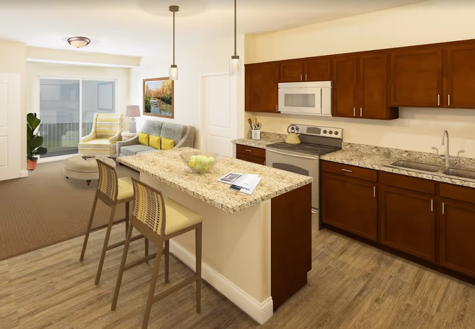 Open-concept kitchen with a granite island and two bar stools opening into a living area with a couch and armchair.