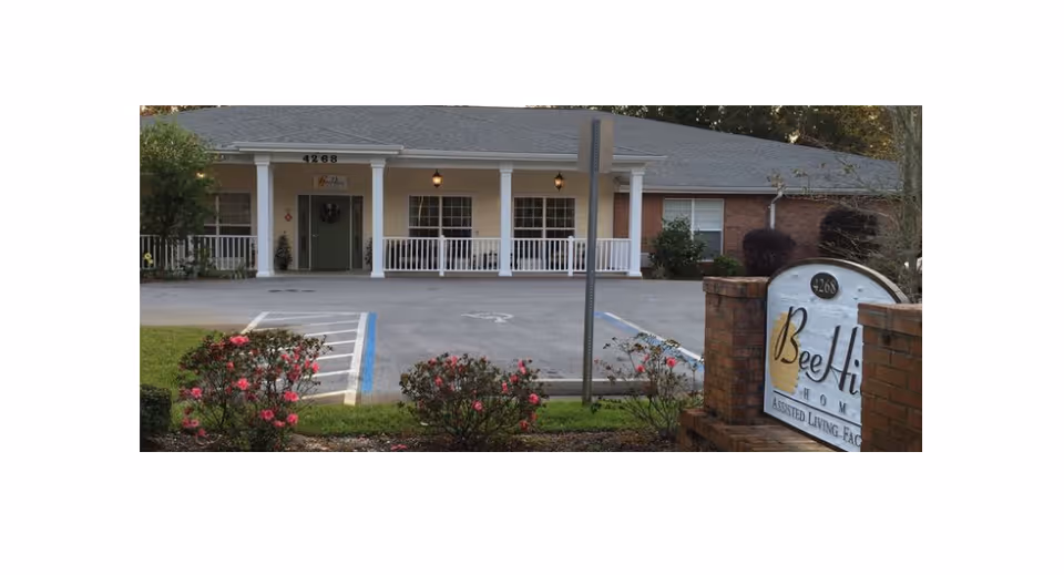 Front view of BeeHive Homes Assisted Living facility with sign and parking.