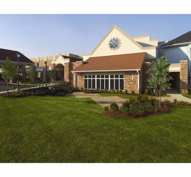 Exterior view of Marymount Place Assisted Living building with manicured lawn and walkway.