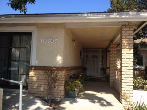 Front entrance of Angels of the Valley Board and Care with brick columns and covered walkway.