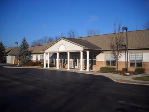 Exterior view of a senior living facility entrance with white columns and a covered portico.