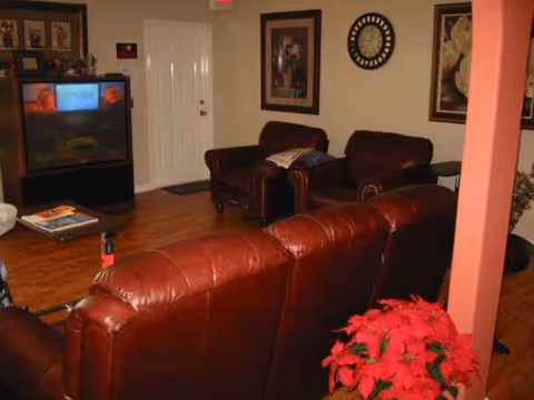 Common living room at Virginia's Lakeview Home with red leather sofas and a TV.