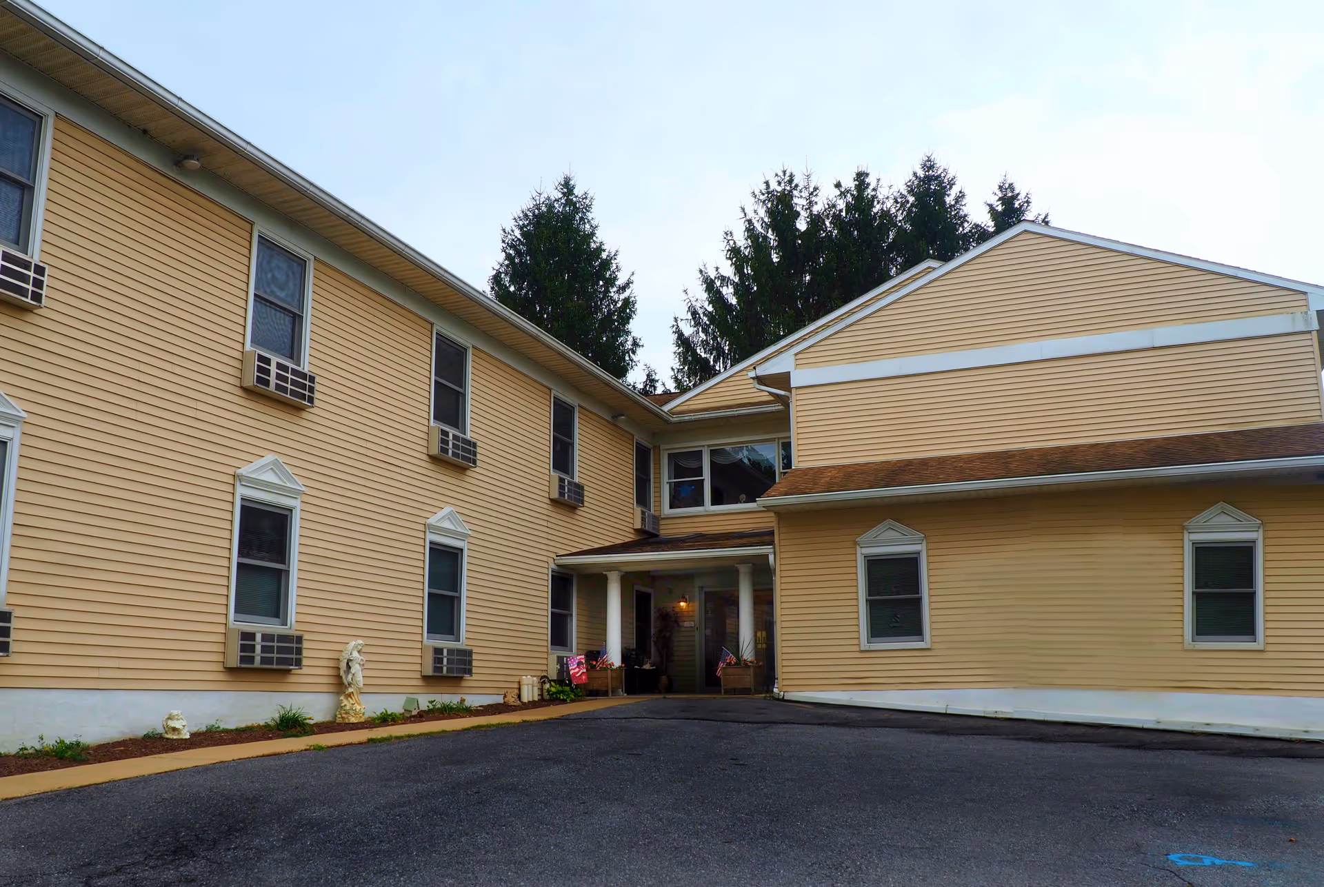 Beige senior living facility exterior with windows and a front entrance.