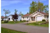 Exterior view of Wesbury United Methodist facility with single-story homes and green lawns.