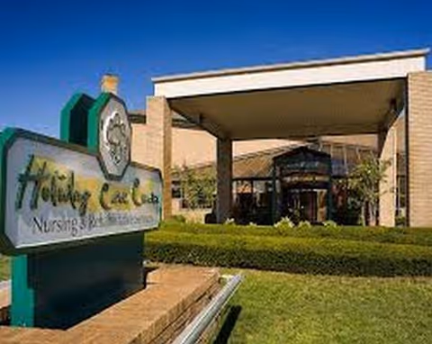 Exterior view of the Complete Care at Holiday City entrance with sign and greenery.