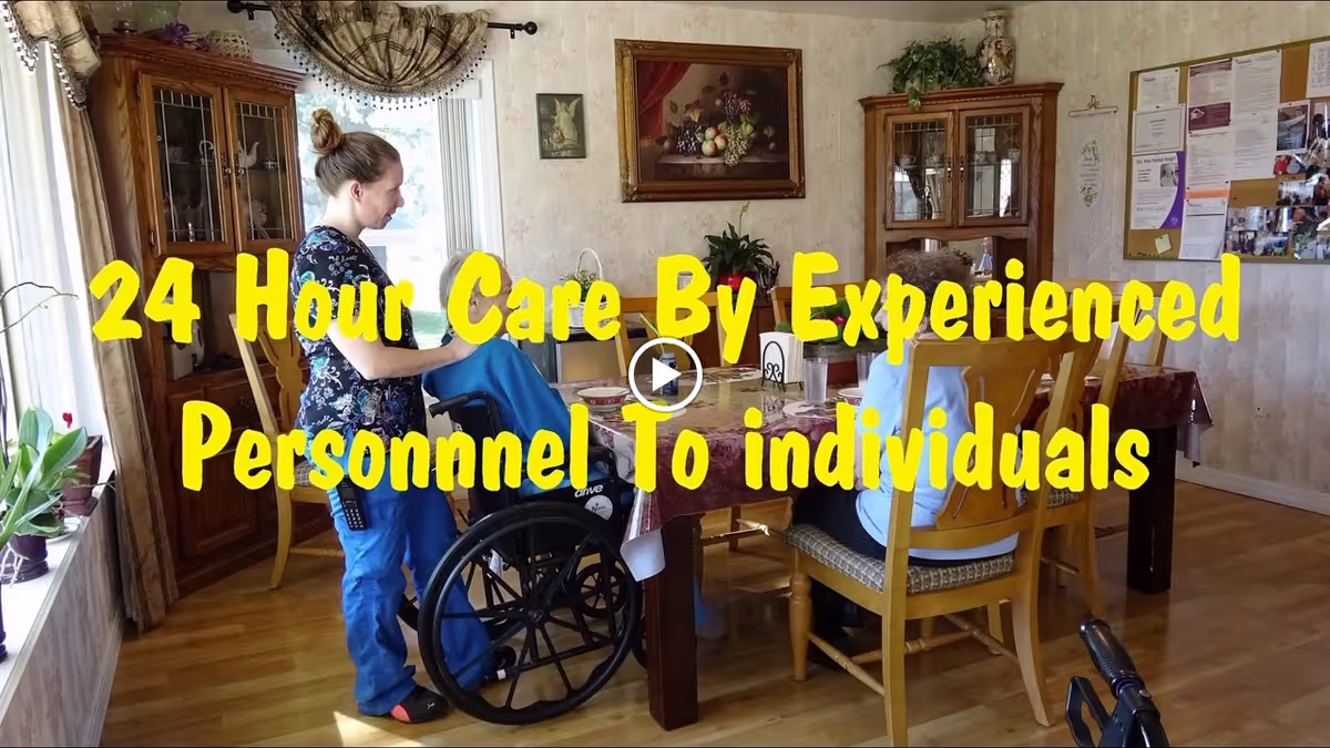 Caregiver assisting a seated resident at a dining table in a home-like dining room with large yellow promotional text overlaid.