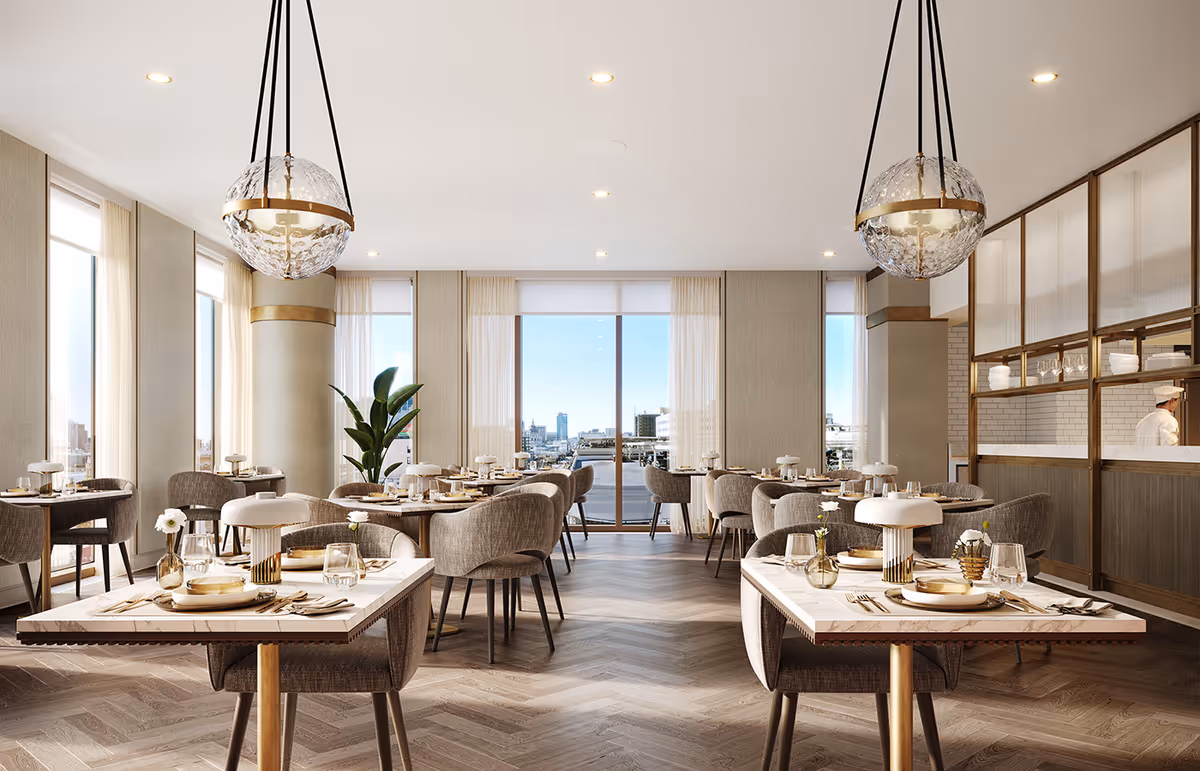 Bright, upscale dining room with neatly set tables, upholstered chairs, large windows showing a city view, and decorative pendant lights.