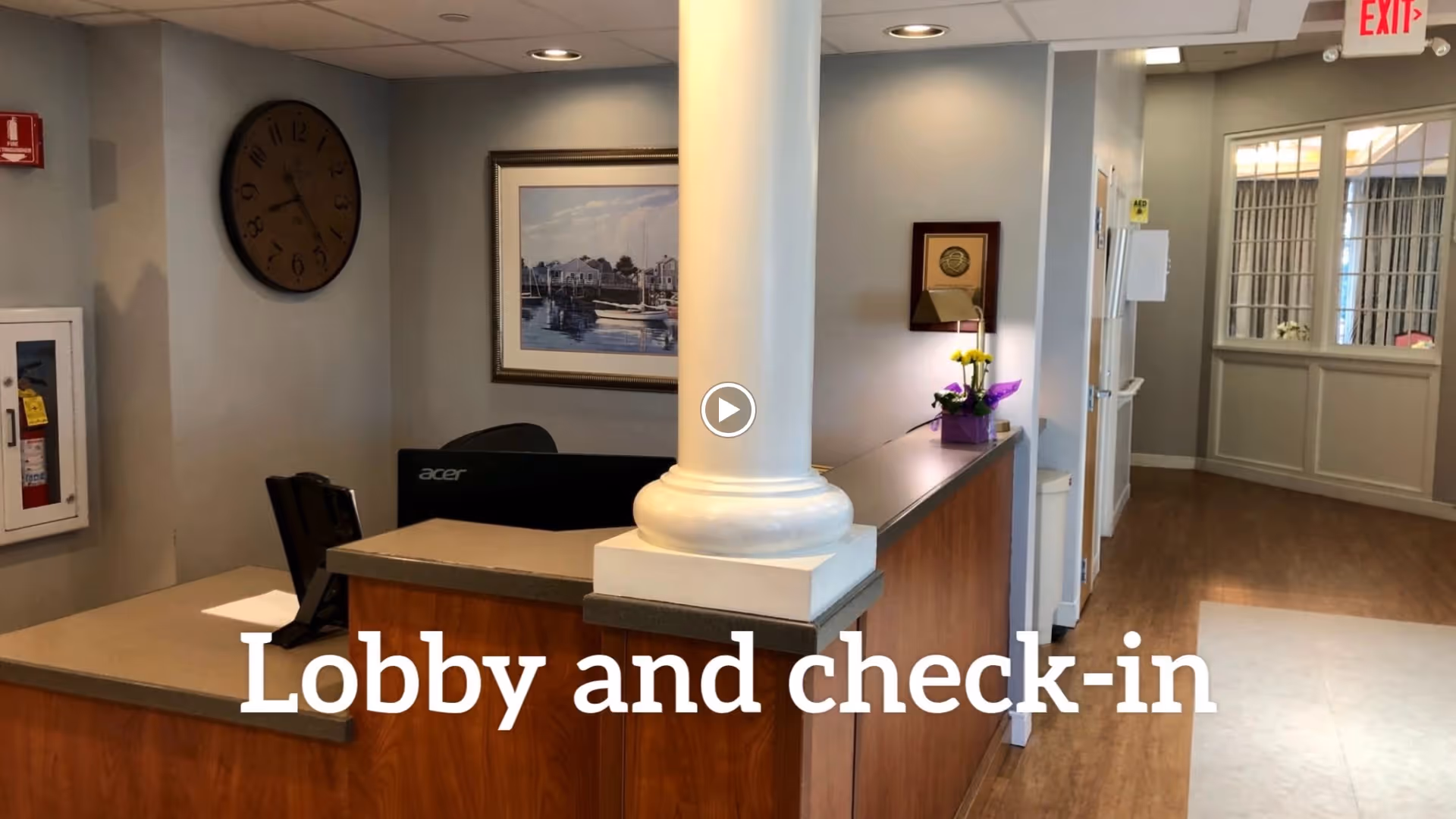Reception desk and lobby area with a central column, artwork on the wall, and a 'Lobby and check-in' text overlay.