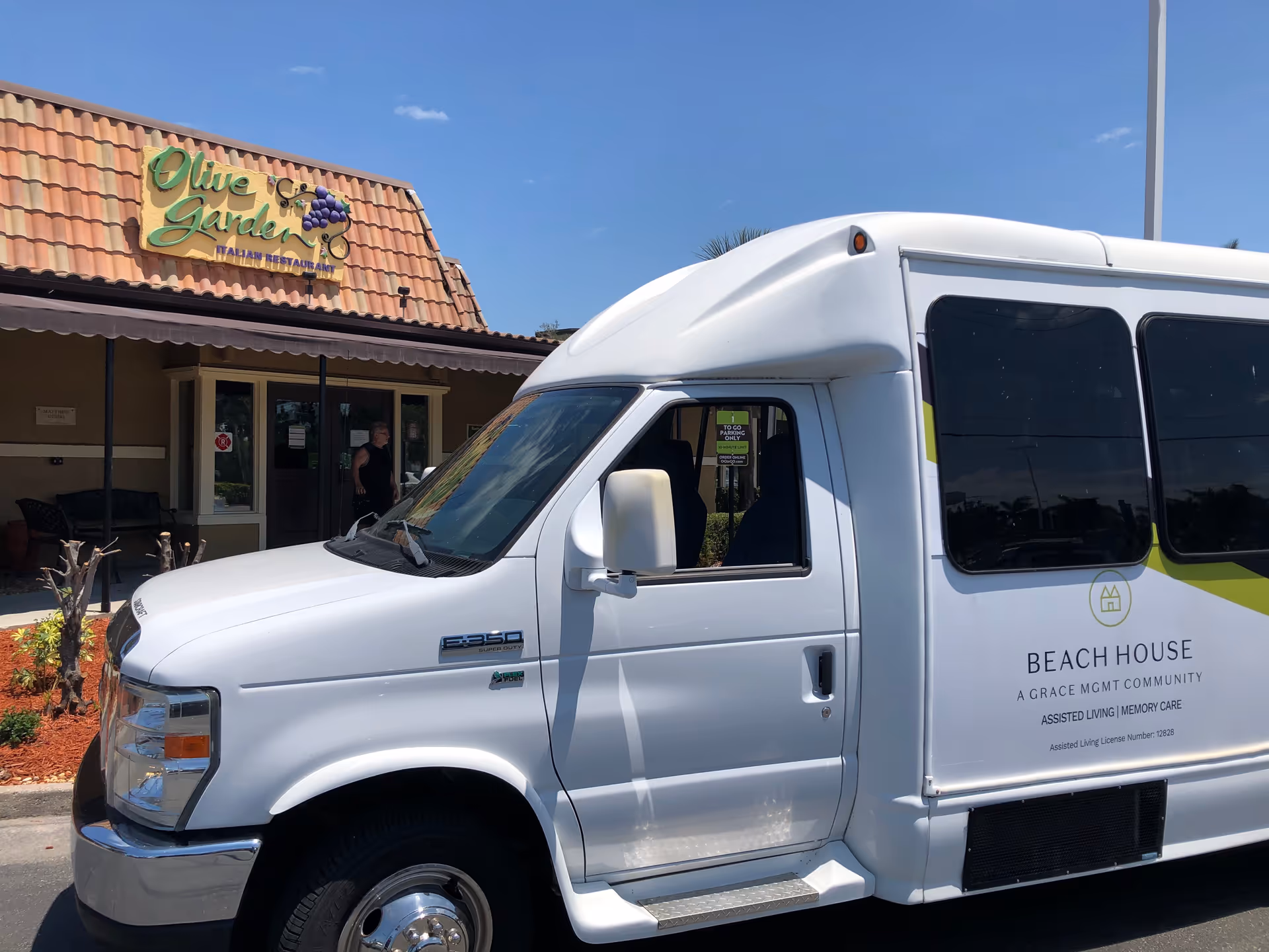 White Beach House branded van parked outside Olive Garden restaurant.