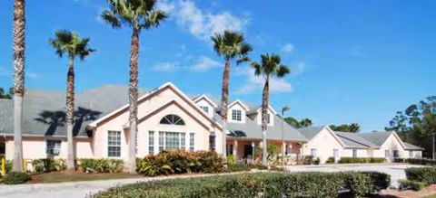 Front view of Brookdale West Melbourne Assisted Living with palm trees and a landscaped yard