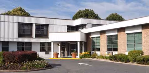 Exterior view of Spruce Manor Nursing & Rehabilitation building with entrance and landscaping.