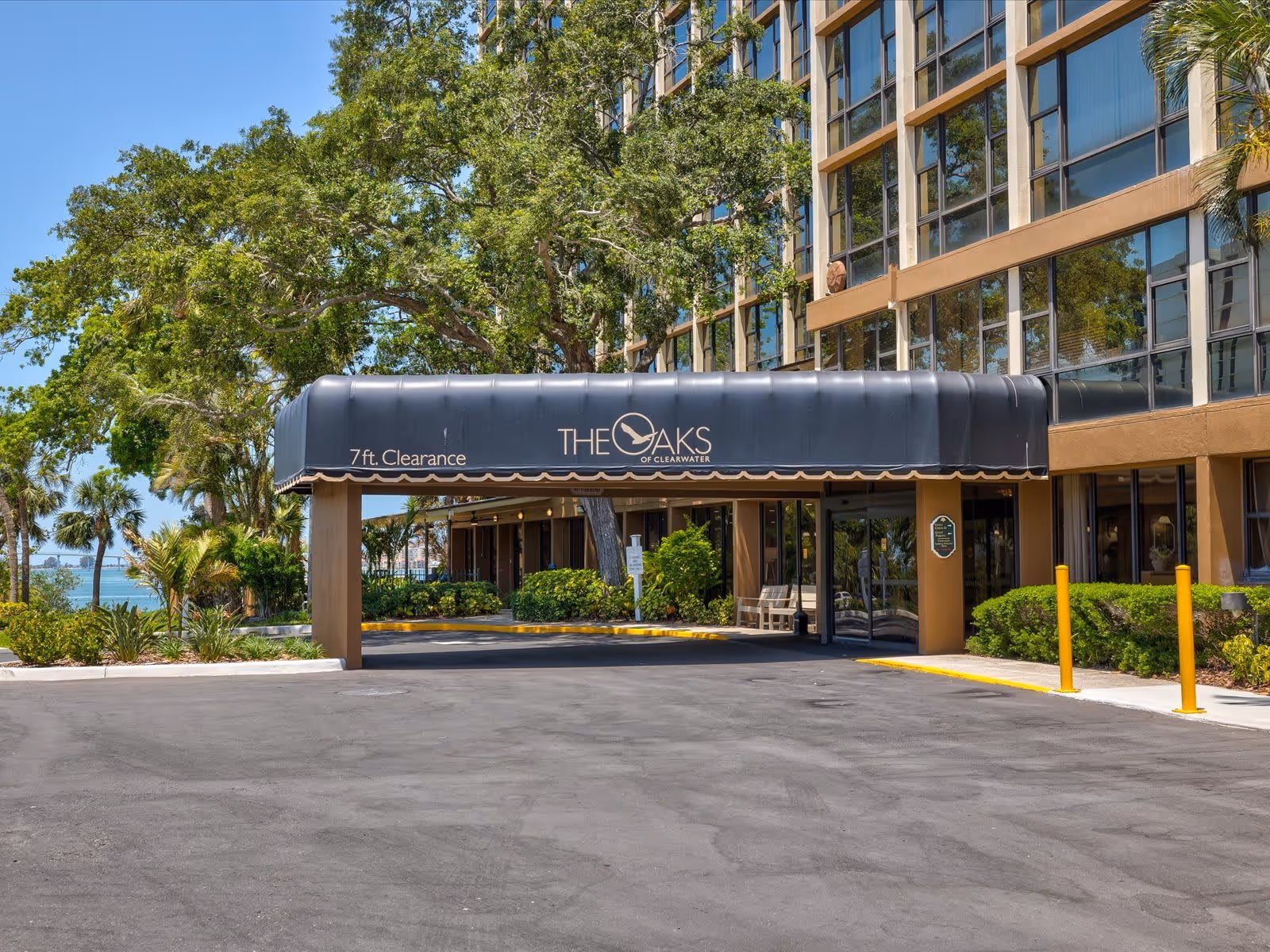 Entrance canopy labeled 'The Oaks of Clearwater' at the front of a multi-story building with trees and a driveway.
