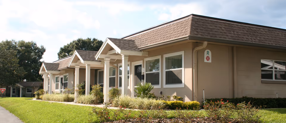 Single-story beige retirement community buildings with small front porches and landscaped lawns.