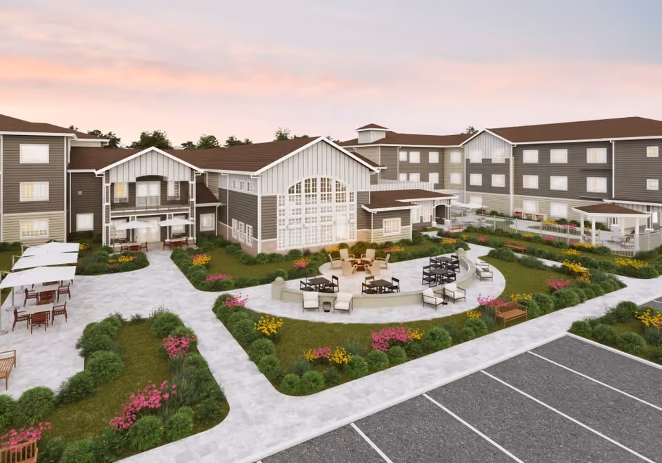 Exterior view of a senior living facility featuring a landscaped courtyard with seating areas and surrounding multi-story buildings at dusk.