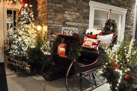 Festive Christmas sleigh and holiday lights decorate the stone entrance of Trouvaille Memory Care Suites.